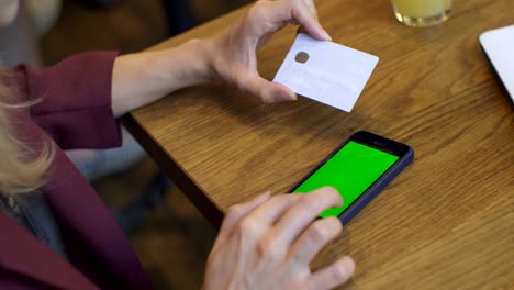 compras en línea. mujer de negocios con una tarjeta de crédito de oro en la mano y compras en internet. pantalla verde, llave de croma