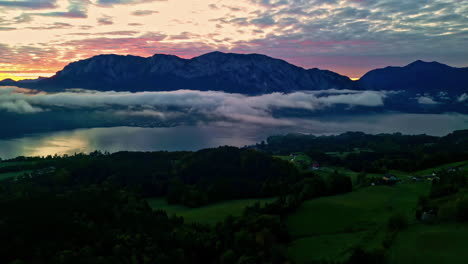 Vista-Aérea-Del-Paisaje-De-Los-Alpes-En-Austria-Durante-La-Puesta-De-Sol-Con-El-Lago-Attersee-Y-Nubes-Encima