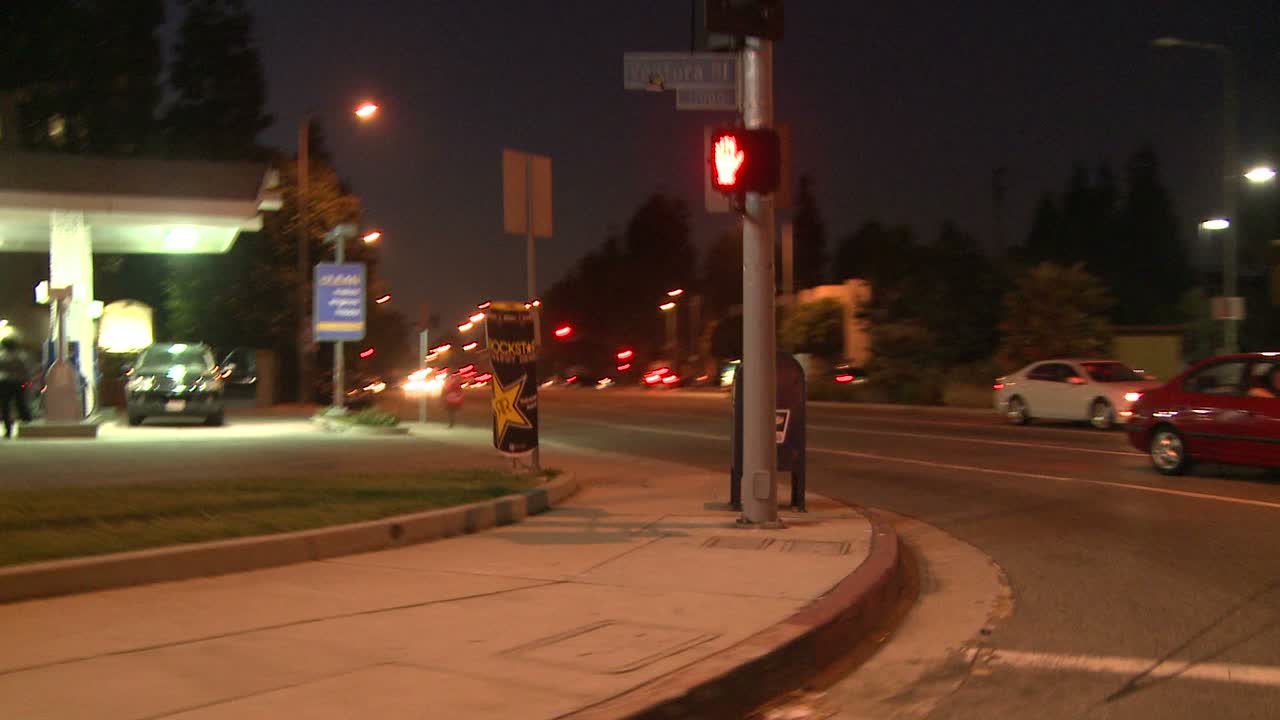 un automóvil viaja a lo largo de una calle por la noche en studio city california, visto a través de la ventana trasera en un ángulo 1
