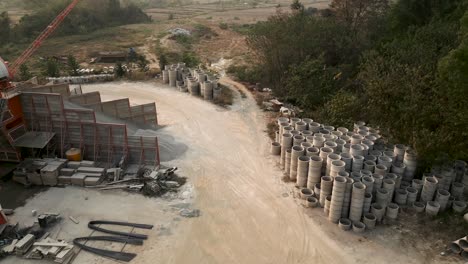 aerial view of a construction material yard with concrete pipes and gravel storage