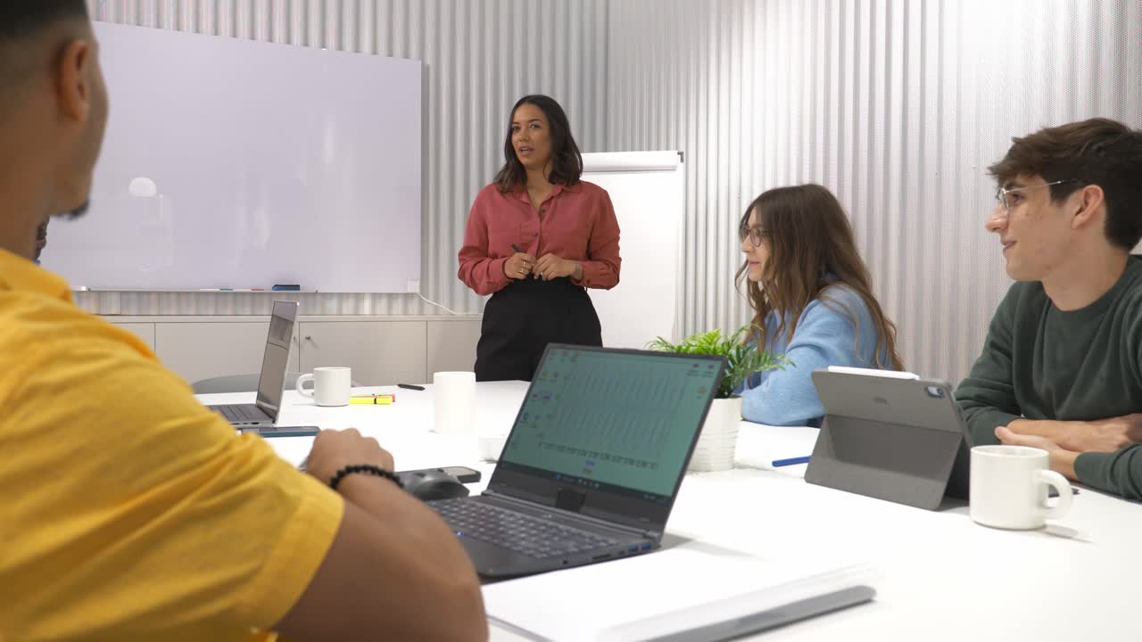 Businesswoman leading creative meeting with diverse team in modern office