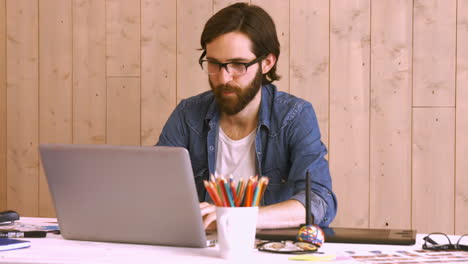 trabajador casual en su escritorio usando una computadora portátil