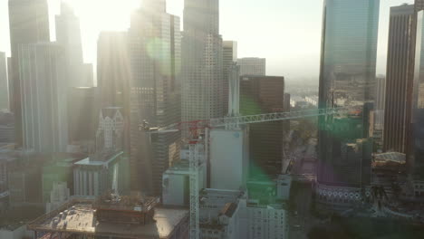 AERIAL:-Flying-towards-Construction-Site-Skyscraper-in-Downtown-Los-Angeles,-California-Skyline-at-beautiful-blue-sky-and-sunny-day