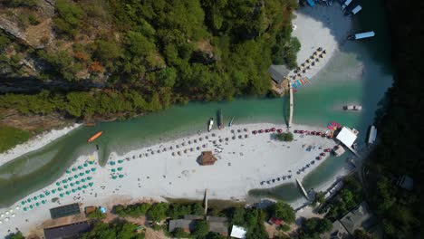 tour boats anchored on shala river, bringing tourists to hidden alpine oasis amidst high mountains