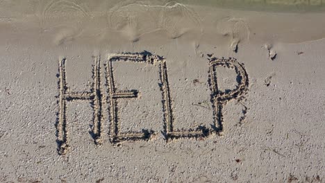 Static-shot-of-HELP-written-in-the-sand