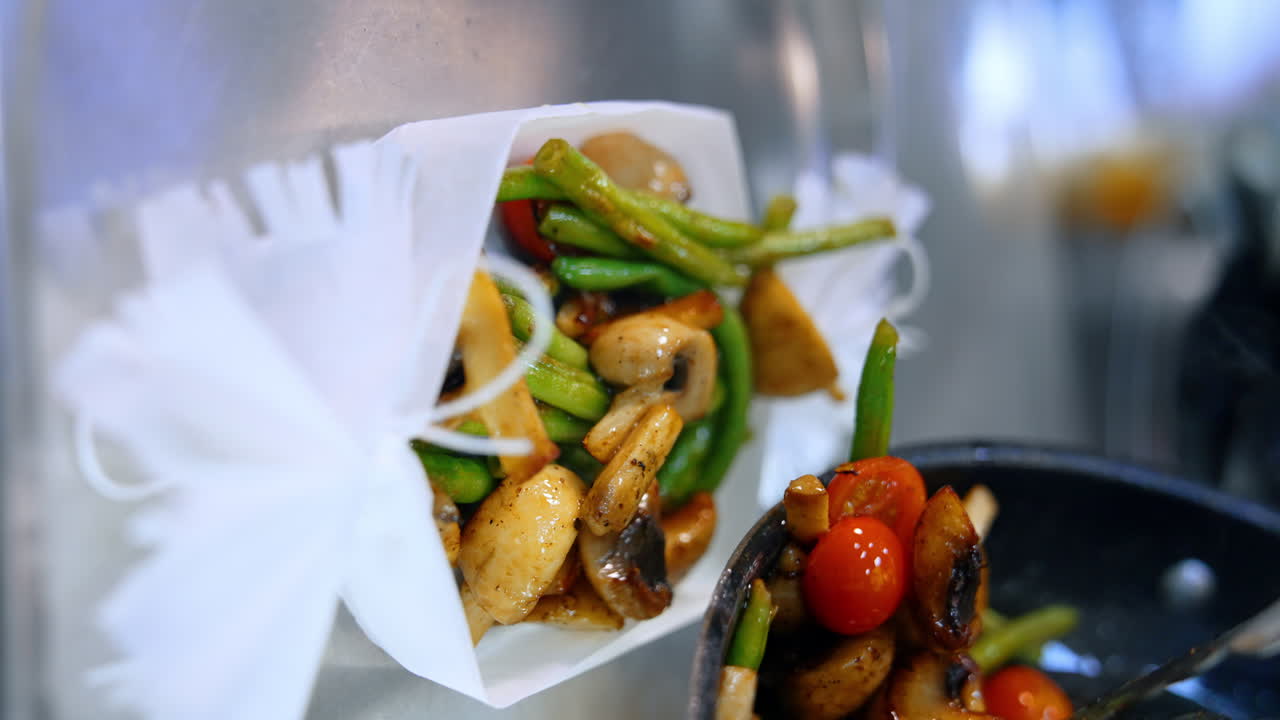 Putting the fried vegetables off the frying-pan. Beans, mushrooms and tomatoes on the plate. Close up. Vertical screen.