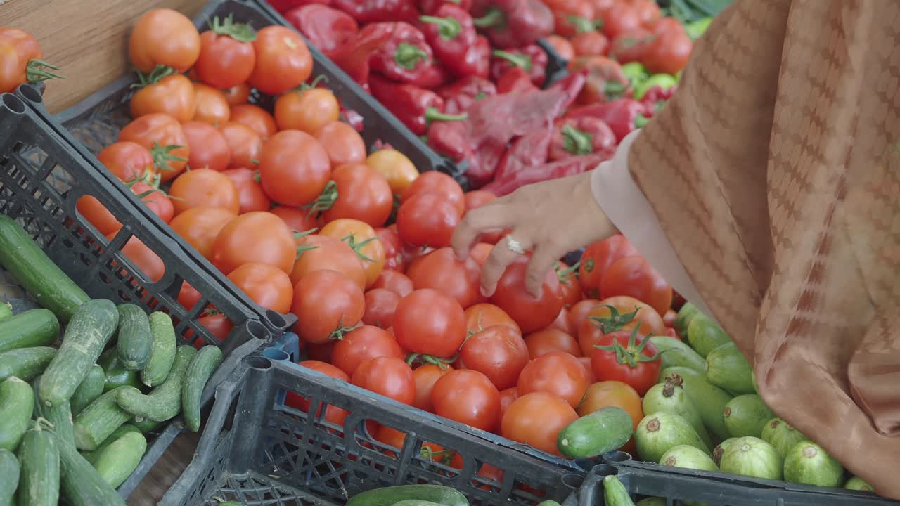 Person selecting fresh vegetables at a market stall