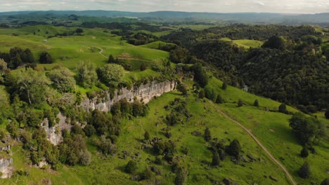 aerial footage new zeland wild nature park green meadow hills and wall rock formation unpolluted area