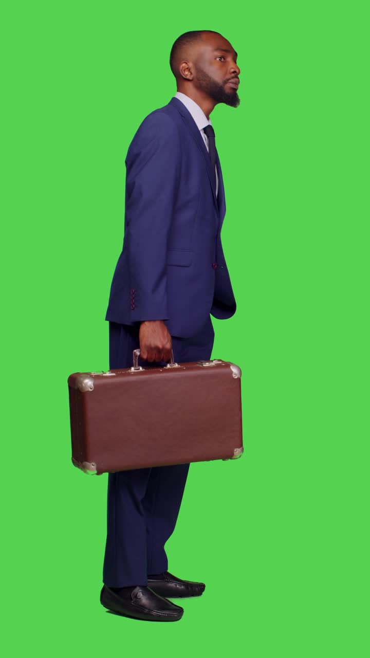 Vertical video: Profile of young manager holding suitcase at company workplace
