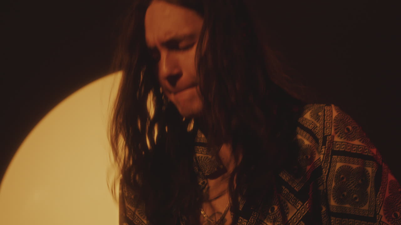 Young Musician Playing Guitar during Concert in Dark Studio