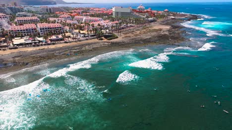 surfers riding waves near arona coast in the canary islands, aerial view