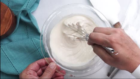 making a dessert called red raspberry tea cake made with fresh berries and vanilla buttercream frosting. great for tea parties. whisking the cake ingredients together in a clear glass bowl