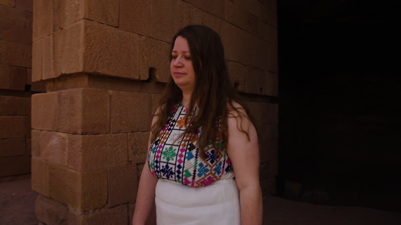 Turista con vestido explorando las antiguas maravillas de Petra, un sitio Patrimonio de la Humanidad de la UNESCO en Jordania.
