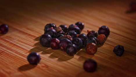 Black-peppercorn-on-a-wooden-surface-with-dramatic-lighting,-camera-orbiting