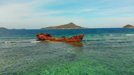 a shipwreck on a reef with epic views of islands in the background in the caribbean