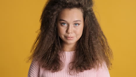 Caucasian-curly-haired-woman-smiling-to-the-camera.