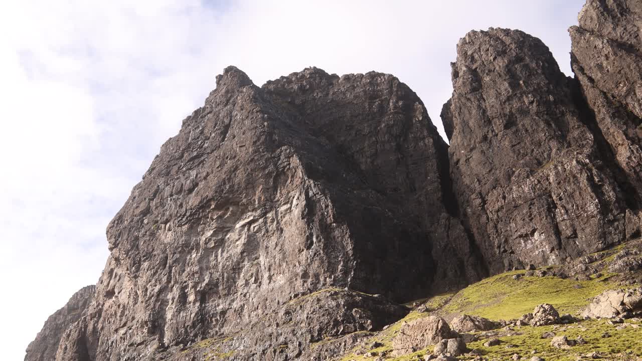 mirando hacia arriba a las caras negras del acantilado del anciano de storr en la isla de skye, tierras altas de escocia
