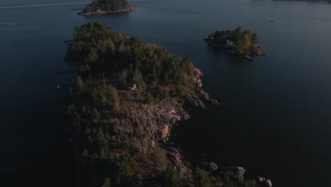 imágenes aéreas de islas rocosas con una cabaña en el archipiélago finlandés