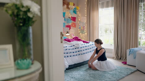 happy teenage girl dancing in bedroom wearing ballet tutu having fun practicing dance moves at home