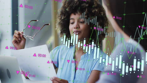 Animation-Von-Daten-Zur-Diagrammverarbeitung-über-Eine-Geschäftsfrau-Mit-Gemischter-Abstammung,-Die-Im-Büro-Mit-Einem-Kollegen-Spricht