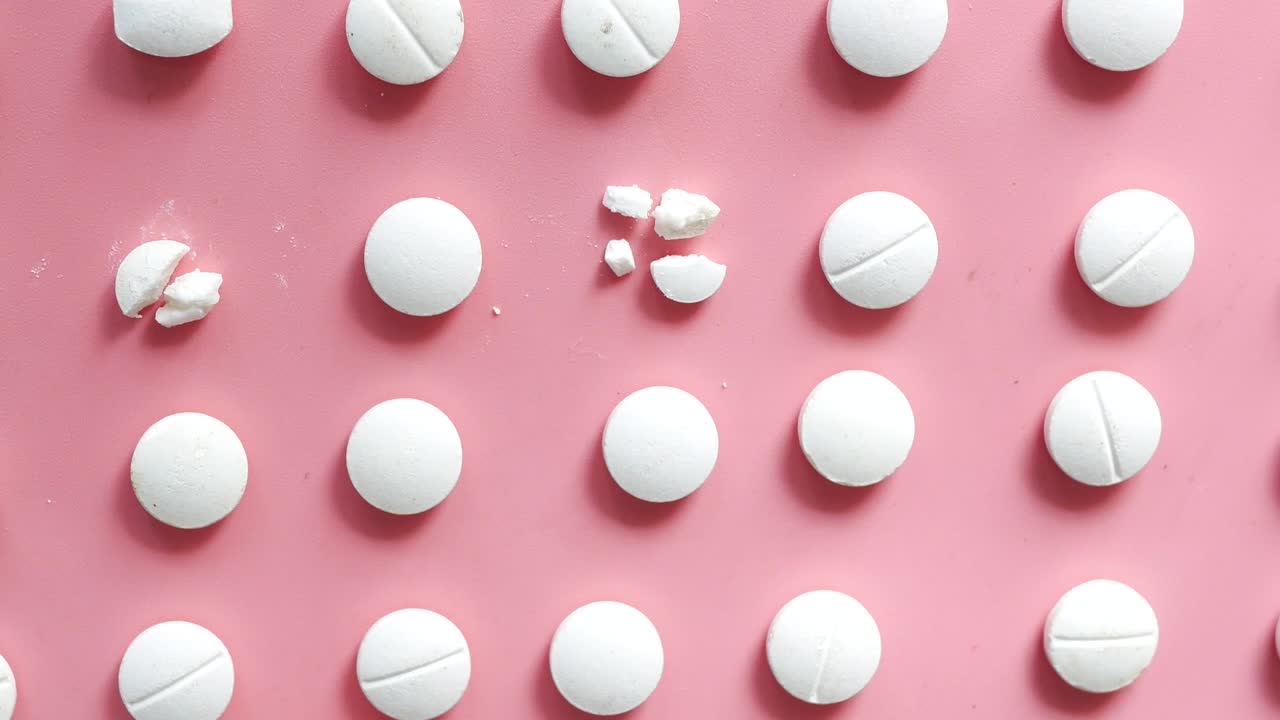 pastillas blancas dispuestas sobre un fondo rosado