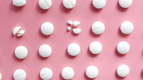 arranged white pills on pink background