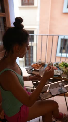 woman enjoying a meal on a balcony