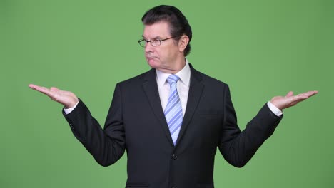 senior handsome businessman choosing between left and right