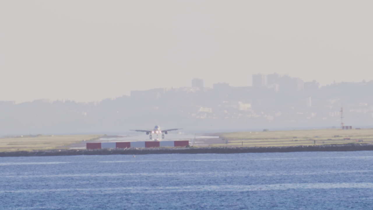Distant view of airplanes landing at the Nice Cote d'Azur Airport in daylight