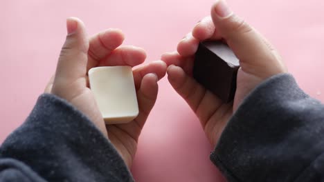 child's hands holding white and dark chocolate