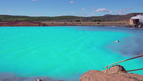 vivid volcanic blue water behind the active volcano of krafla in myvatn iceland signs warn of dangerous conditions