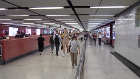 commuters walking through a busy subway station hallway