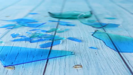 broken turquoise glass on a light blue wooden table