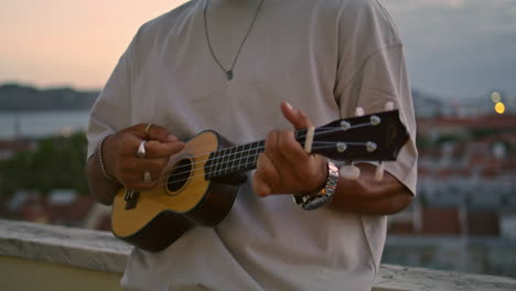 Chico-Pensativo-Firmando-Terraza-Al-Atardecer-El-Fin-De-Semana.-El-Hombre-Toca-El-Ukelele-Por-La-Noche.