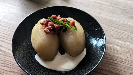 traditional lithuanian dish of potatoes with cream elegantly served on a plate in a restaurant.