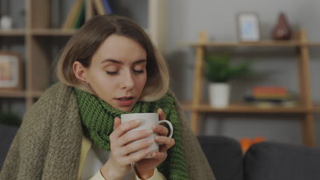woman with a cold drinking tea at home.