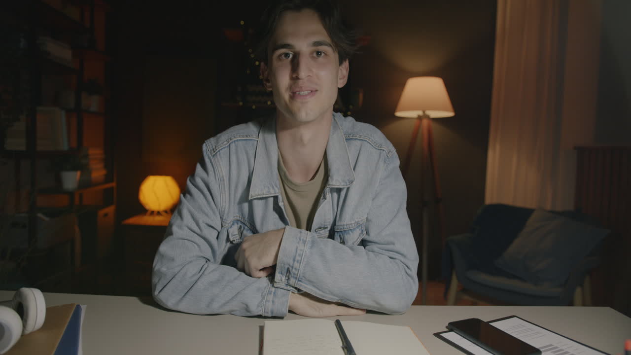 Young man in online meeting at home at night