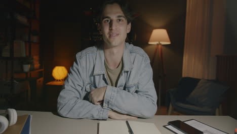 young man in online meeting at home at night