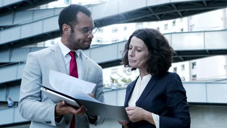 Focused-business-colleagues-looking-at-papers