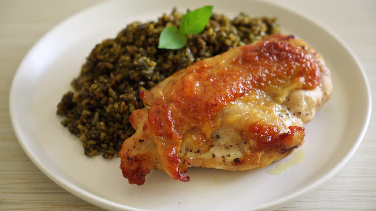 riso fritto al pesto con pollo alla griglia su piatto bianco