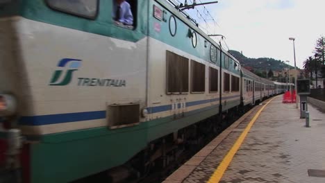 un tren pasa por un patio de trenes y una ciudad en sicilia italia