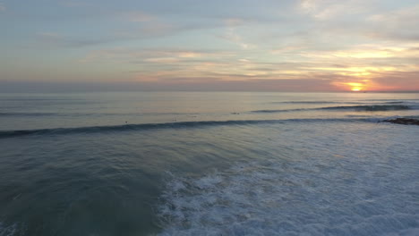 Schöner-Sonnenuntergang-Am-Strand-Von-Costa-De-Caparica-In-Der-Nähe-Von-Lissabon-Mit-Einigen-Surfern-Auf-Dem-Rahmen