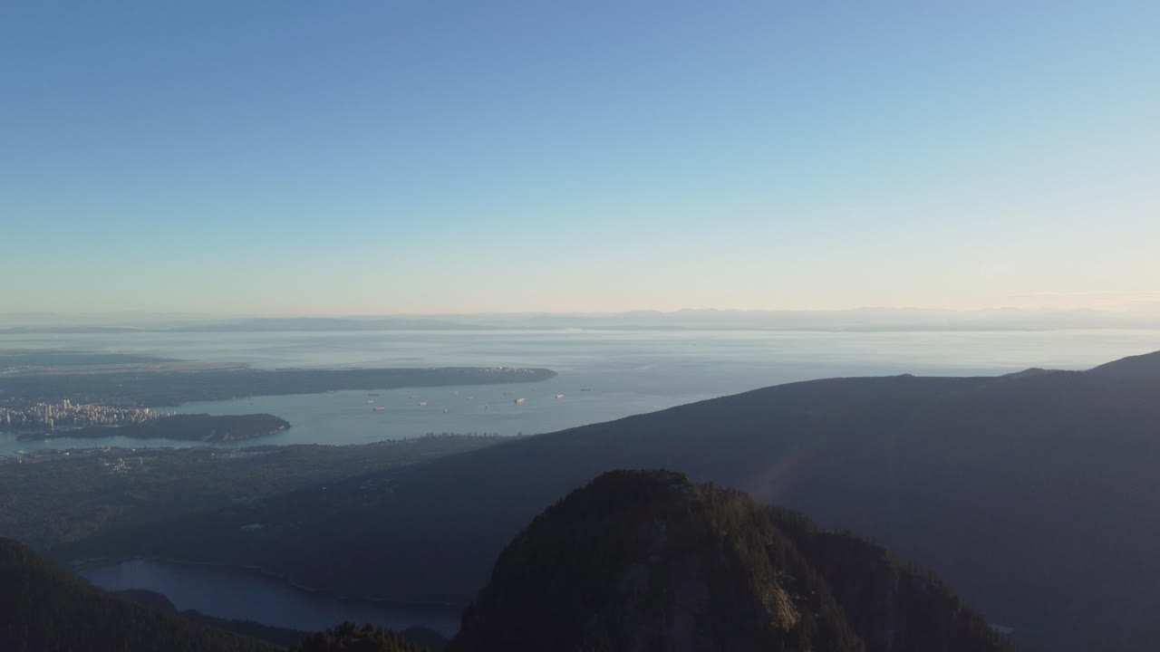 도시 경관과 화물선이 있는 일몰 시 밴쿠버 bc 캐나다의 공중 전망 - 패닝 드론 샷