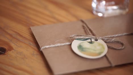 sobre de regalo con etiqueta de manzana en una mesa de madera