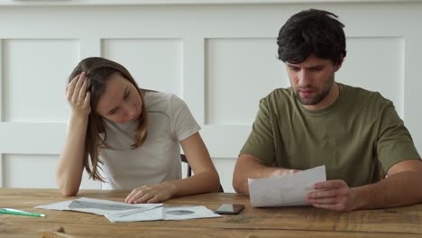 stressed young couple calculating monthly home expenses, credit card bills payment