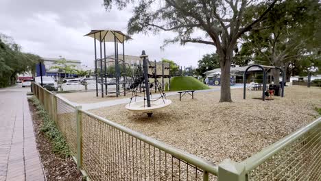 children playing at a city park playground near a river