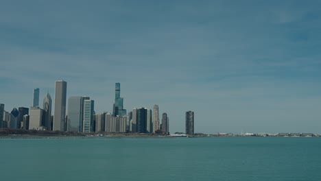 revealing chicago's spectacular skyline across lake michigan's teal waters on clear spring day