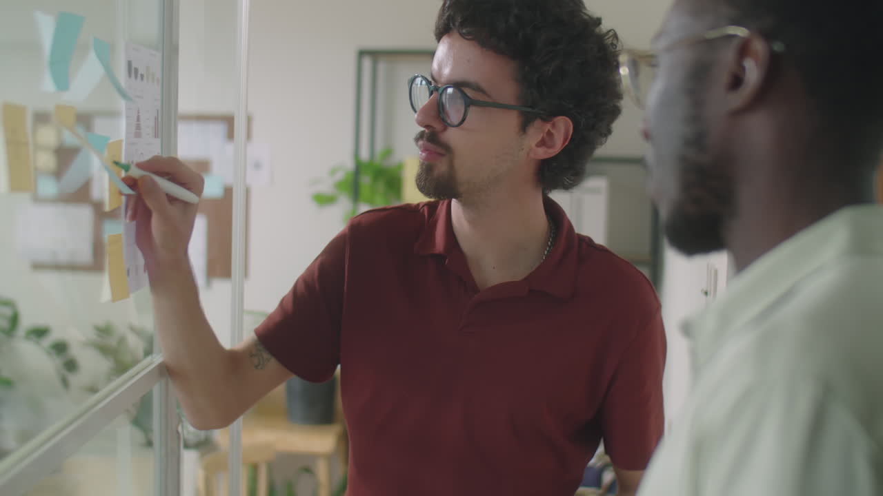 Coworkers Using Sticky Notes and Talking in Office