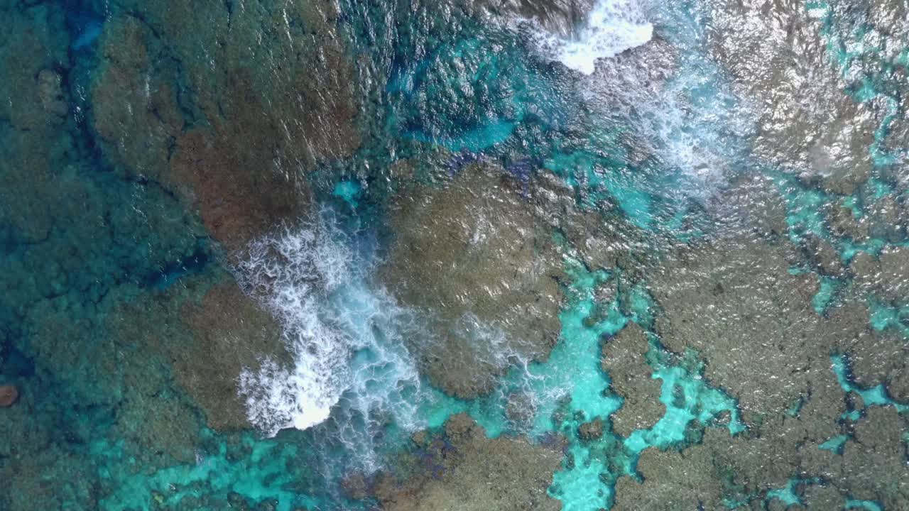 A drone captures a shot of a blue lagoon, showcasing the crystal-clear waters that reveal the stunning underwater landscape, 