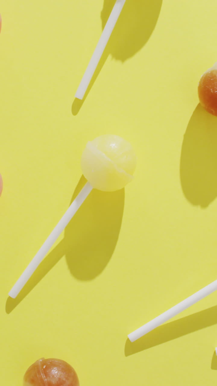 video de piruletas multicolores sobre un fondo amarillo